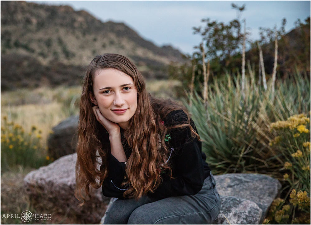 High School Senior Girl with wry smile at her senior portrait session at East Mount Falcon Trailhead in Morrison Colorado