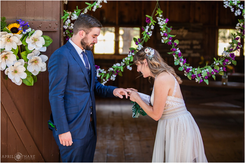 Bride puts ring on groom's finger during their outdoor wedding ceremony on Lookout Mountain in Golden Colorado