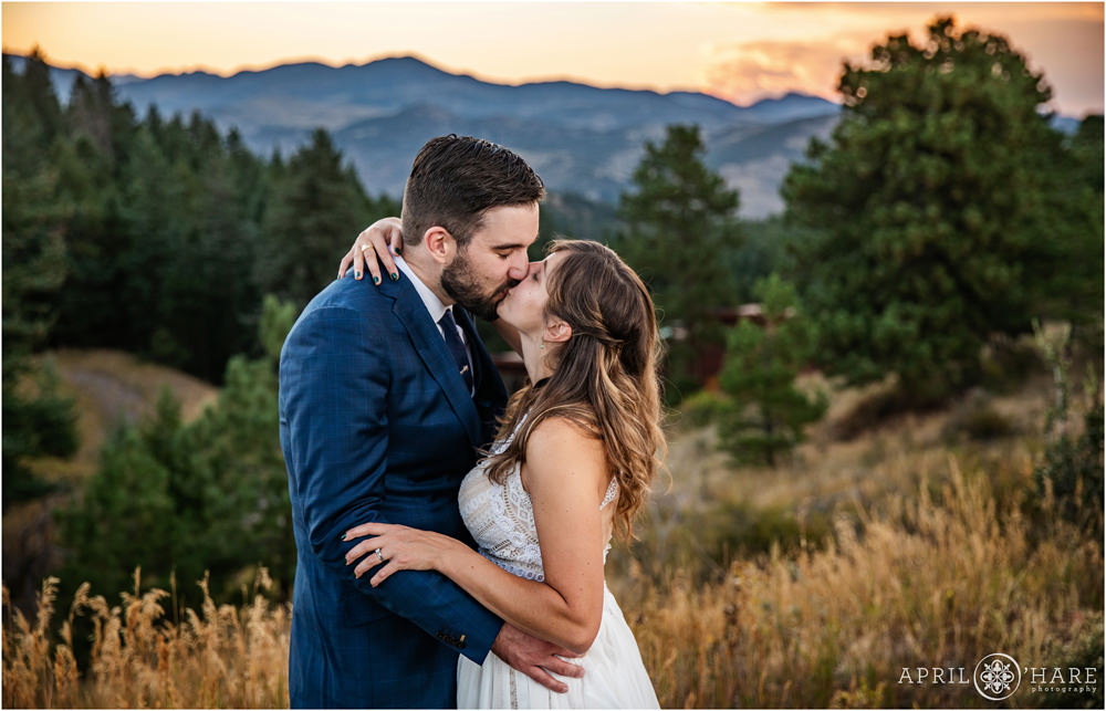 Bride and groom kiss each other in front of a pretty sunset mountain backdrop on Lookout Mountain