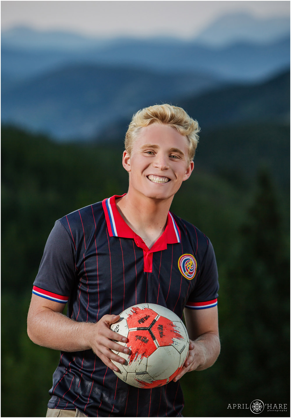 Senior boy soccer player portrait wearing his jersey in the mountains of Colorado