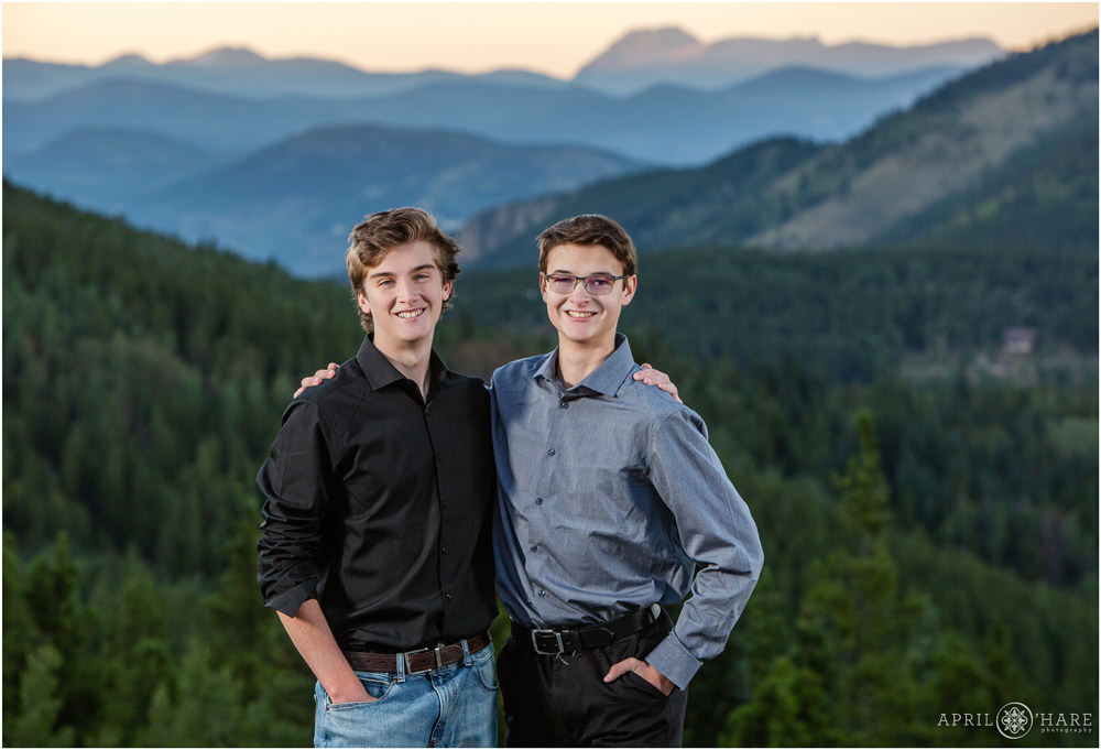 Two fraternal twin brothers with mountain backdrop at their senior session in Evergreen
