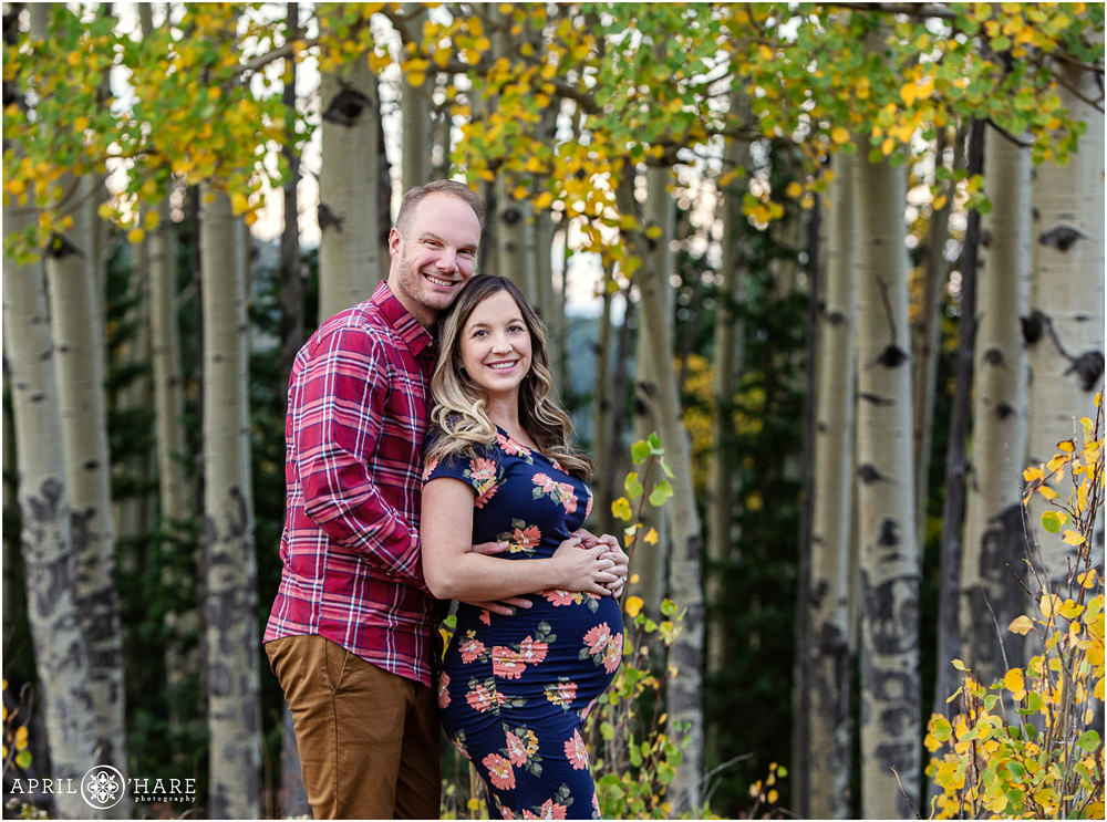 Beautiful fall color maternity picture with a mix of green and yellow aspen leaves