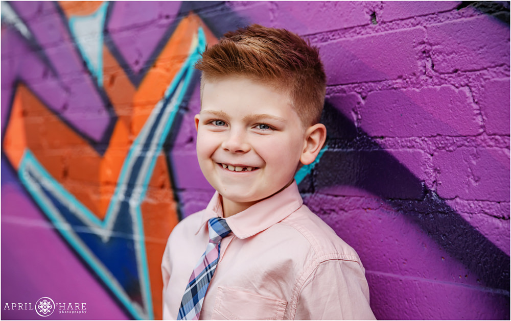Bright Mural Backdrop for a young boy's photo at his family photography session in Rino Denver