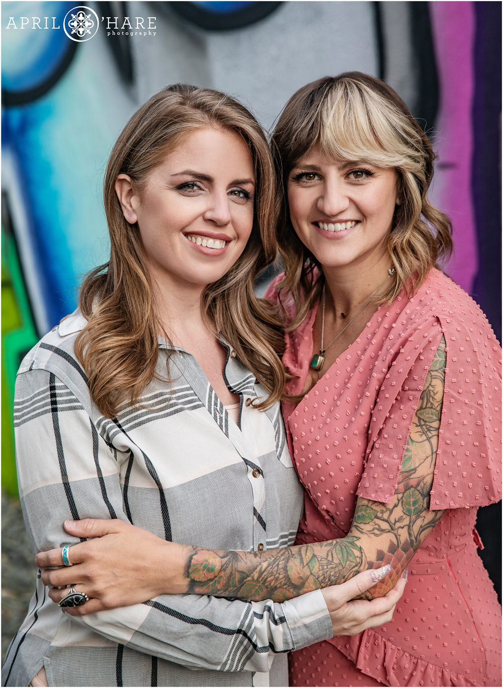 Two sisters pose for a photo in front of street art mural in Rino area of Five Points in Denver CO