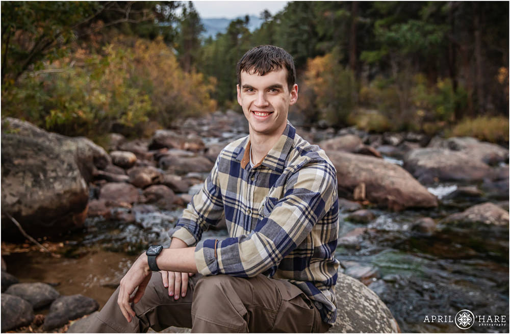 Oldest son in the family poses for his own headshot portrait with a pretty river backdrop at RMNP