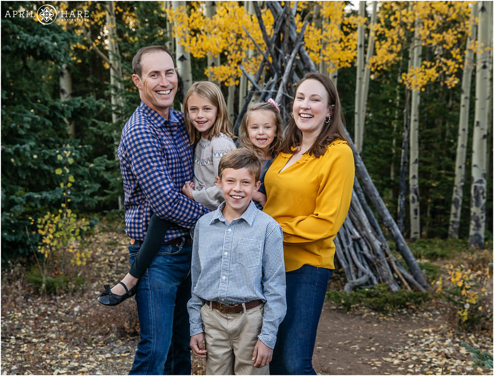 Family laugh together in a pretty aspen tree forest on Squaw Pass Road in Evergreen Colorado