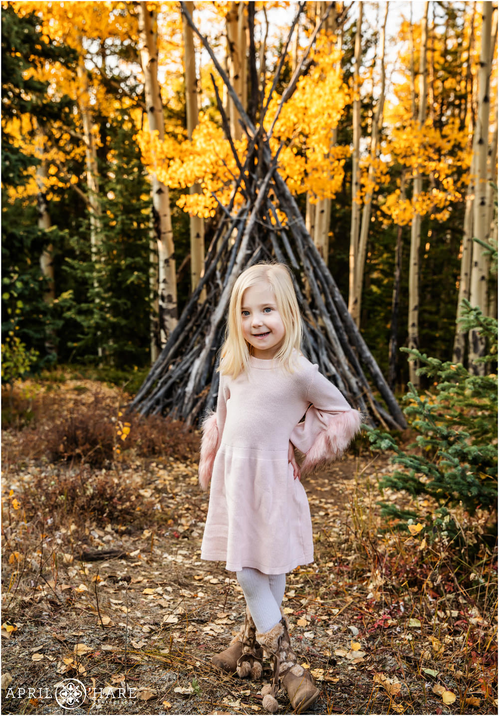 Adorable little blonde girl wearing a light pink dress poses in the fall color on Squaw Pass Road