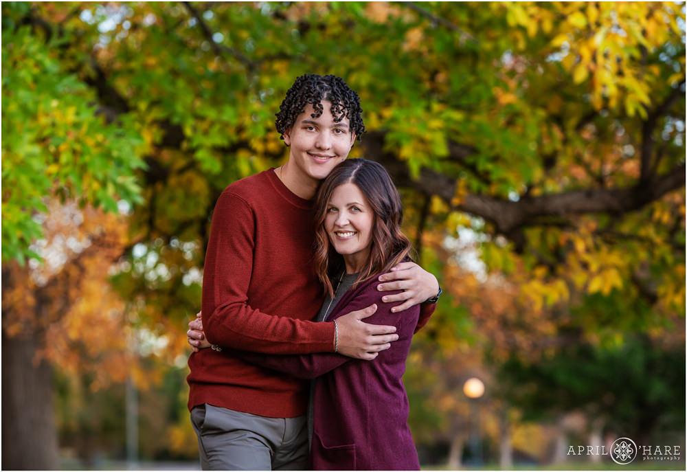 High school senior boy gets a photo with his mom in the fall color at City Park in Denver CO