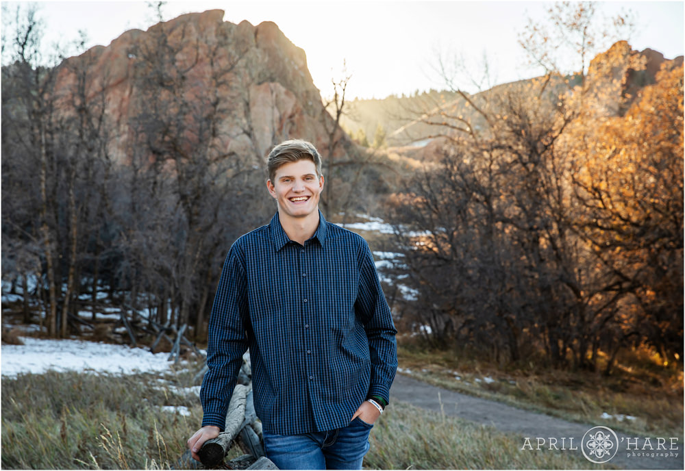 High school yearbook photo for a young man wearing a dark blue button up dress shirt with pretty red rock backdrop in Colorado