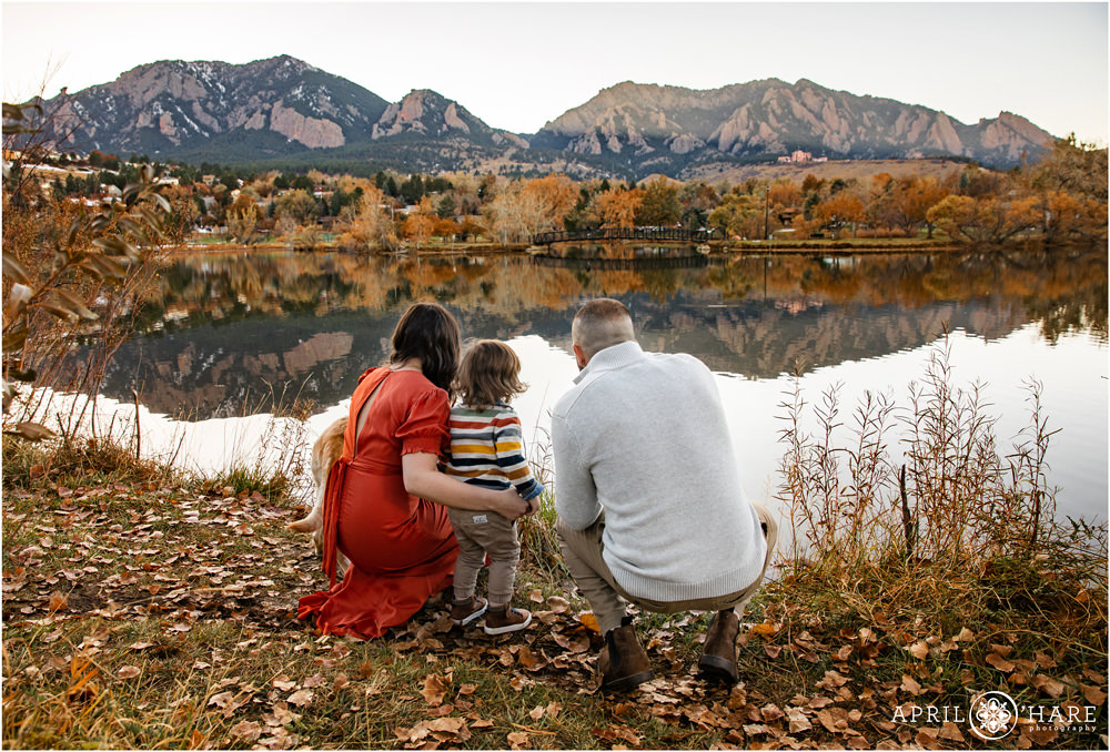 A family of three looks out at the pretty mountain view of Boulder at Viele Lake