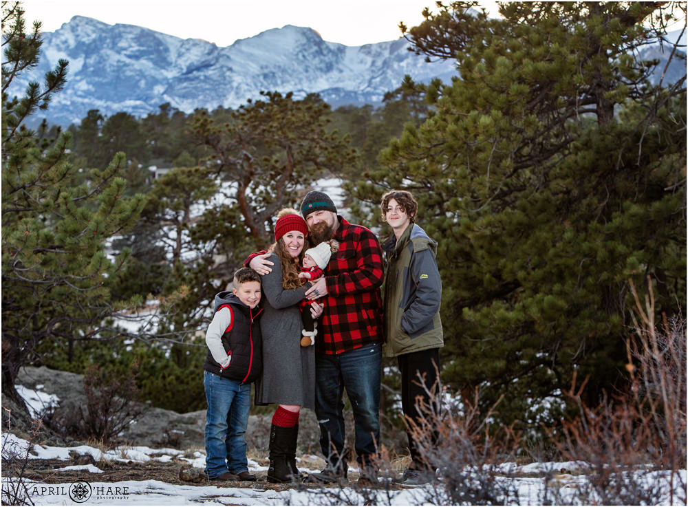 A Family of Five wearing red Christmas Buffalo Check Plaid with mountain backdrop in Estes Park Colorado