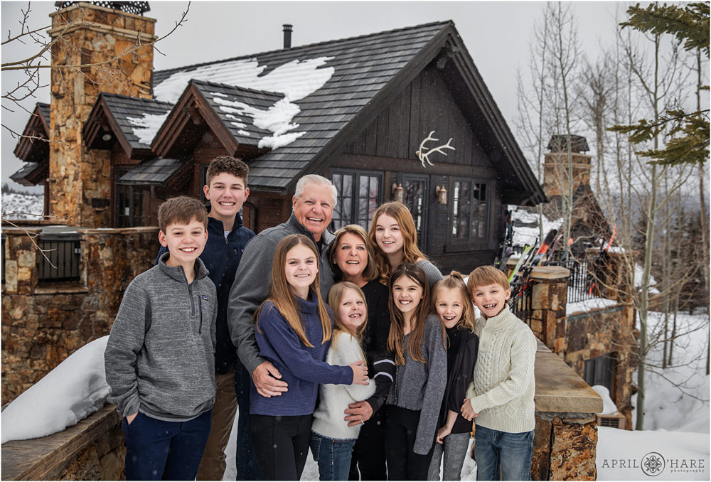 Grandparents pose with their grandkids outside of their mountain home in Beaver Creek Colorado