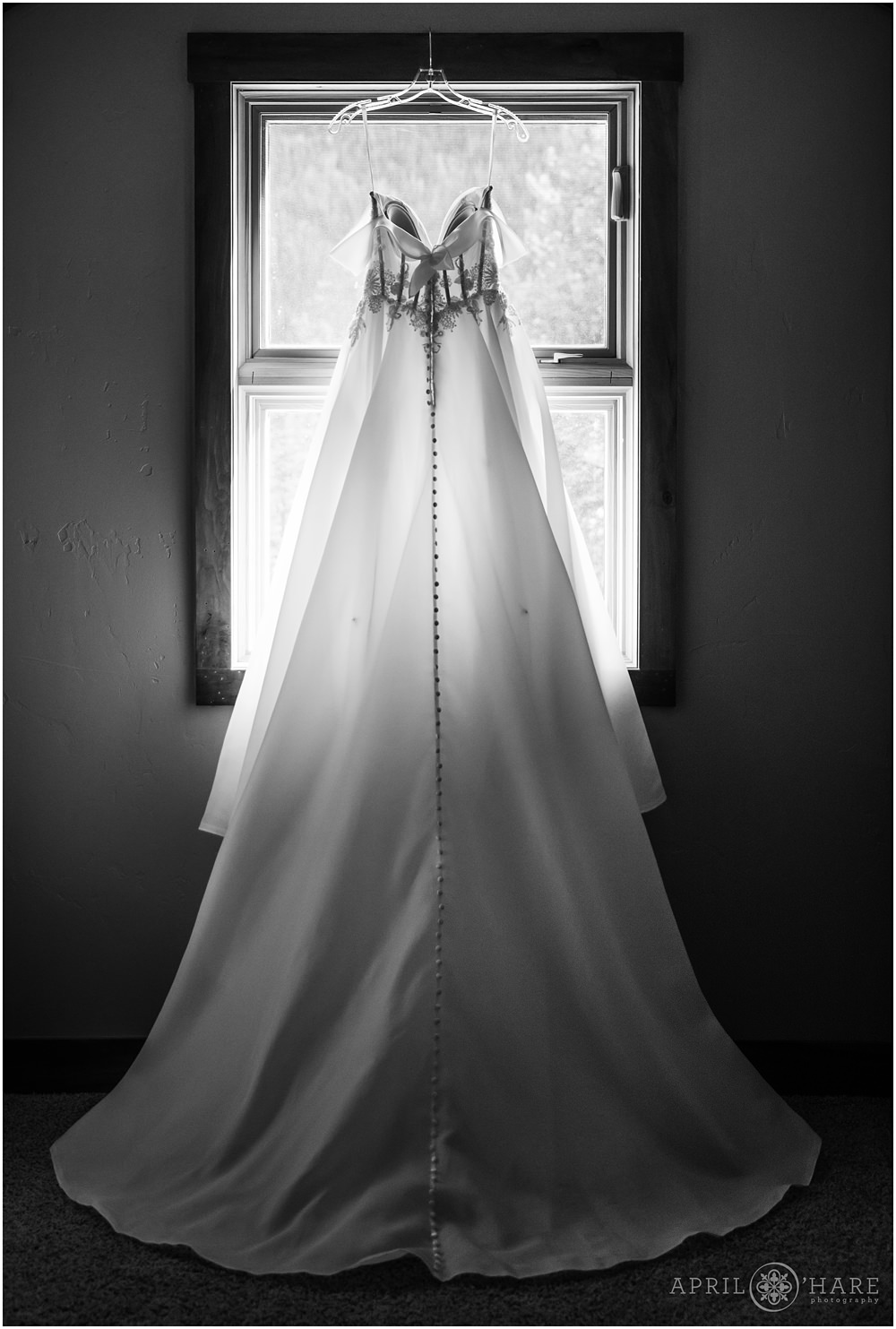 Romantic wedding dress hangs in the window at a Keystone Colorado wedding during winter
