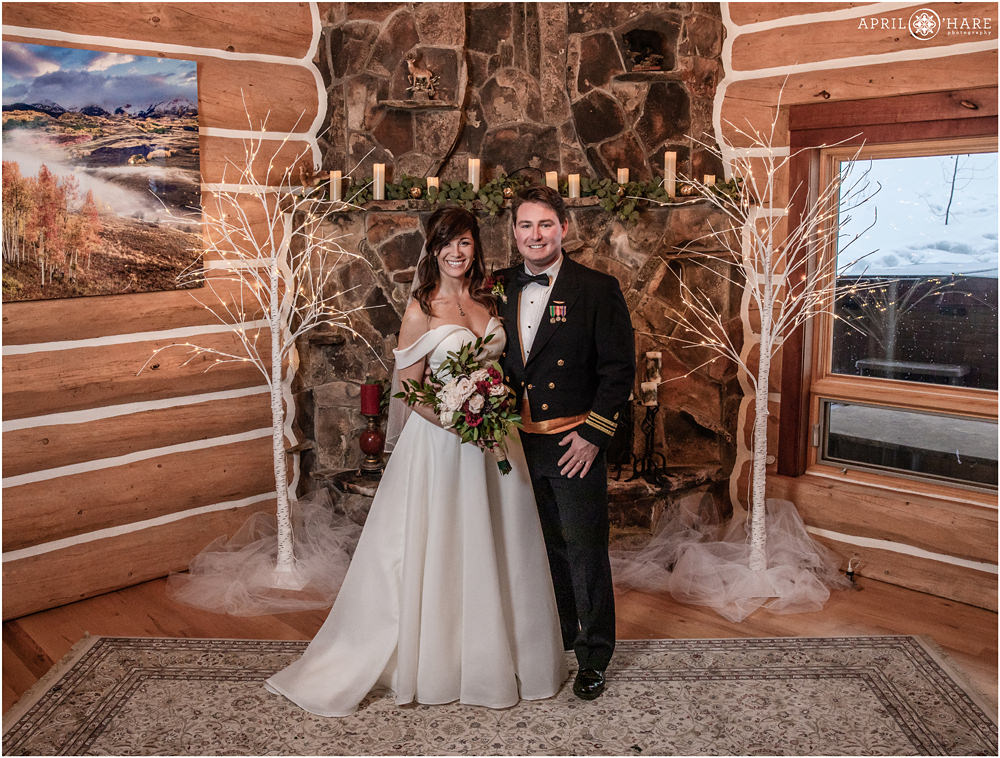 Classic wedding portrait of a couple in front of stone fireplace at private home in Keystone Colorado