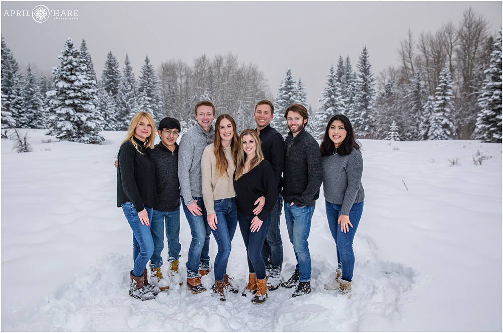 Family stand in the snow posing for a picture together on their trip to Colorado