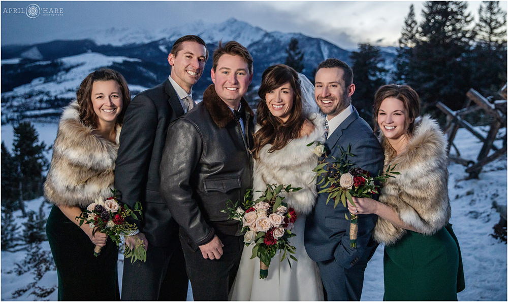 Bride and Groom with their friends pose in the freezing outdoor winter weather on their wedding day at Sapphire Point near Keystone Colorado