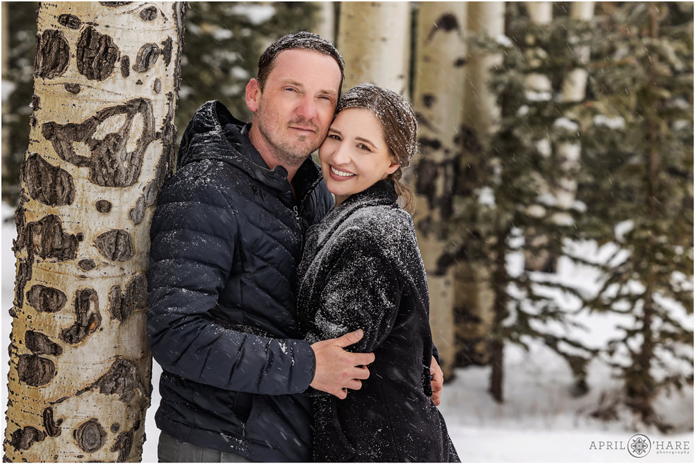 Super snowy engagement style couples portrait with aspen trees in a spring snowstorm in Evergreen Colorado