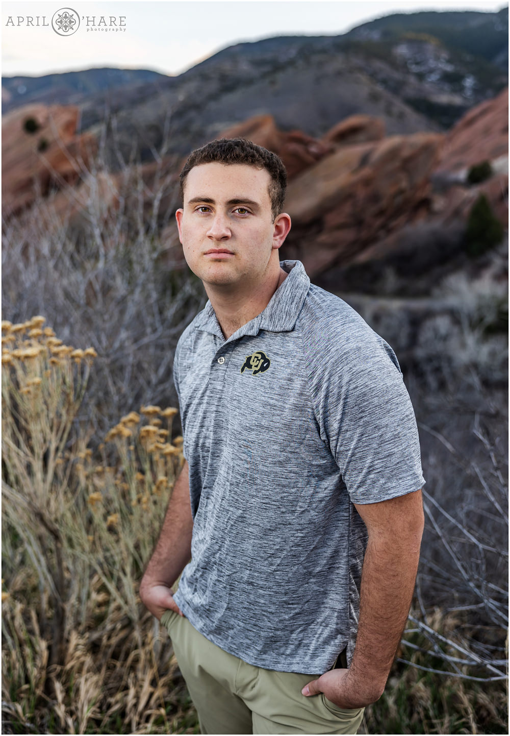 Young man about to graduate from high school wears a CU Boulder shirt for his senior picture at Red Rocks