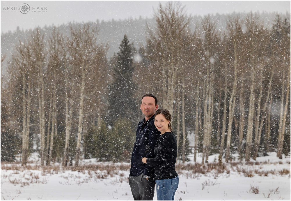Snowy couples photography session with aspen tree backdrop in Evergreen Colorado