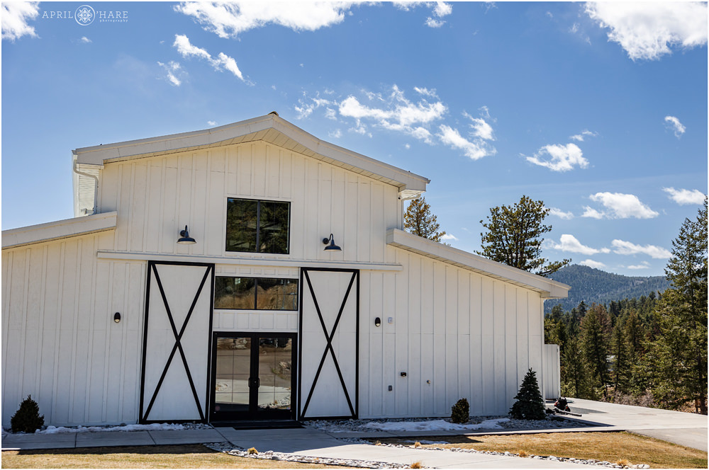 Large White Barn Wedding Venue called Woodlands with forest and mountain views in the backdrop only a short drive from Denver CO on Highway 285