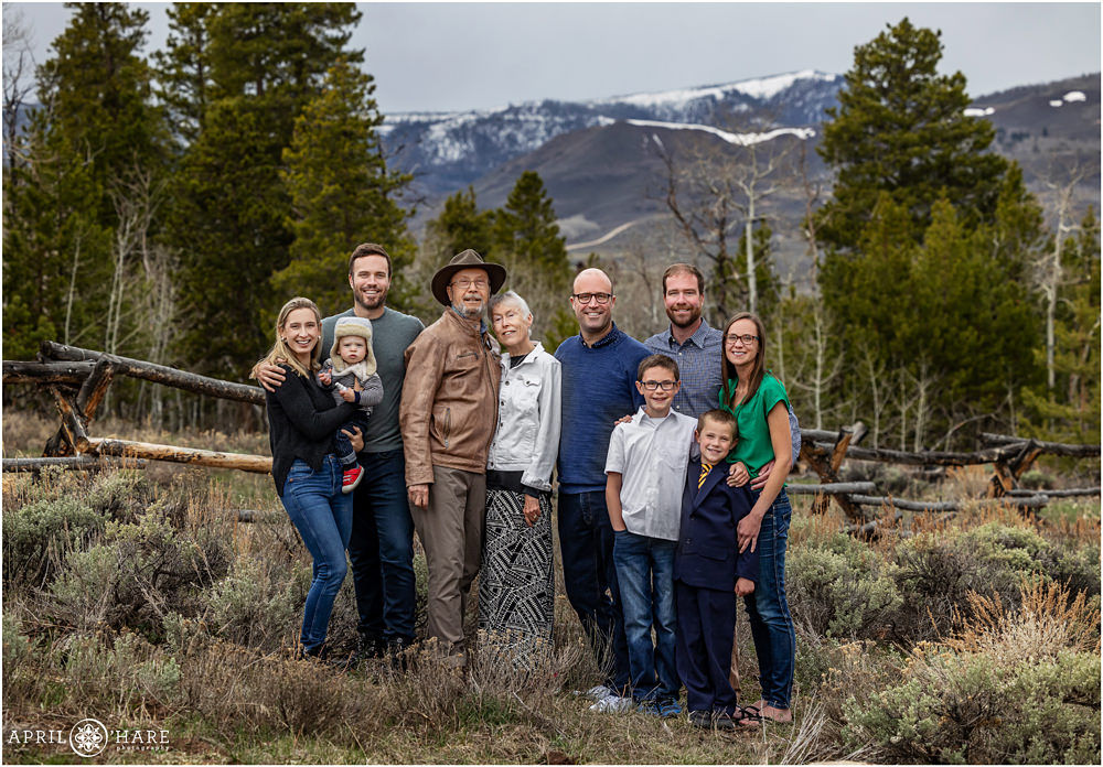 Beautiful Colorado mountain family portrait in front of western style ranch fence at Granby Ranch during May in Colorado