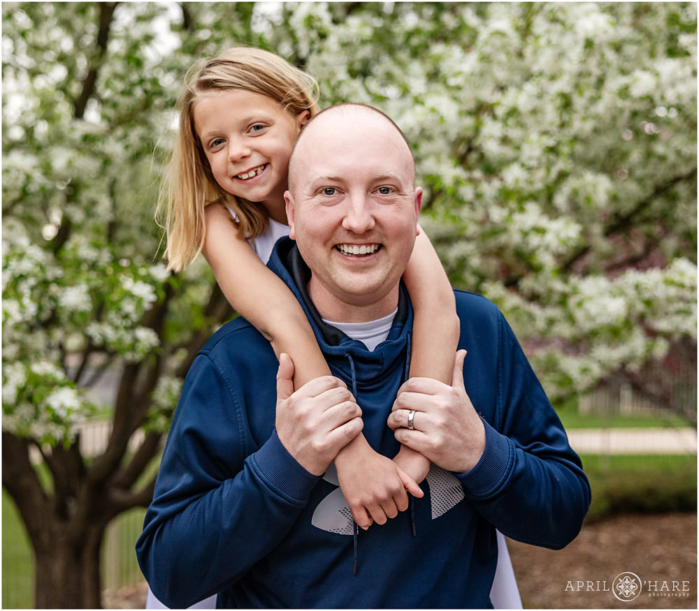 Sweet girl poses for a family picture with her Godfather on the day of her first communion in Denver
