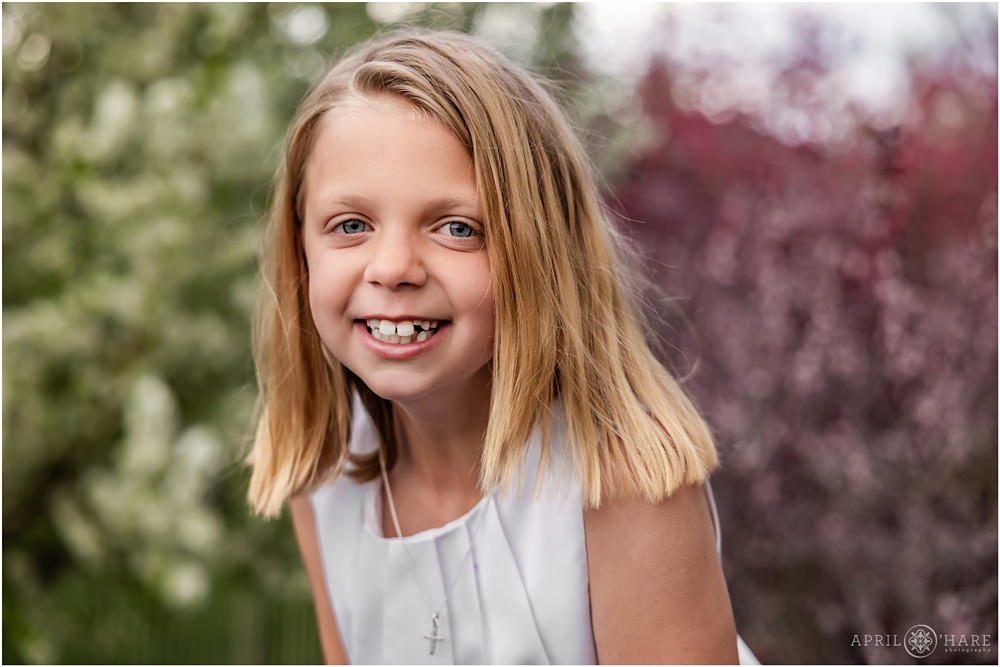 First communion photo with spring blossom backdrop at her backyard in Colorado