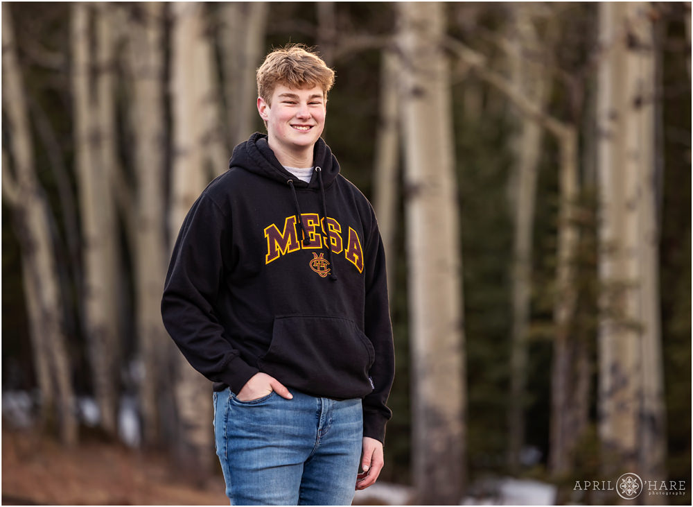 High school senior boy heading to Colorado Mesa University with aspen tree backdrop in Evergreen Colorado