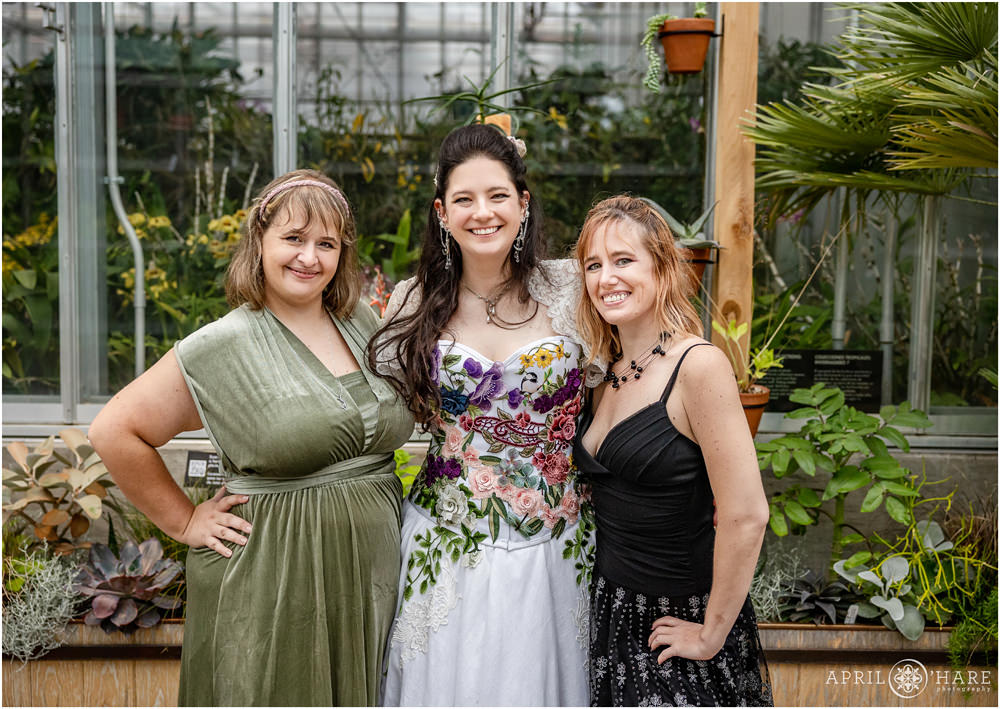 Bride with friends inside the Orangery on her rainy wedding day at Denver Botanic Gardens