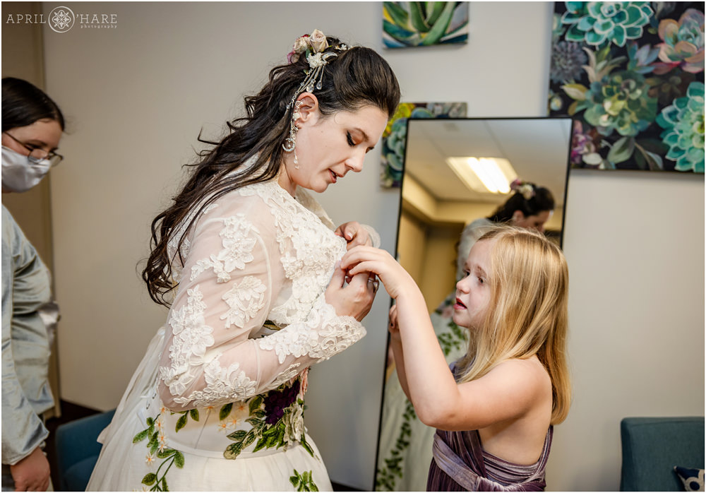 Bride gets some help from the flower girl with her lace bolero in the classroom of Marnie's Pavilion at Denver Botanic Gardens