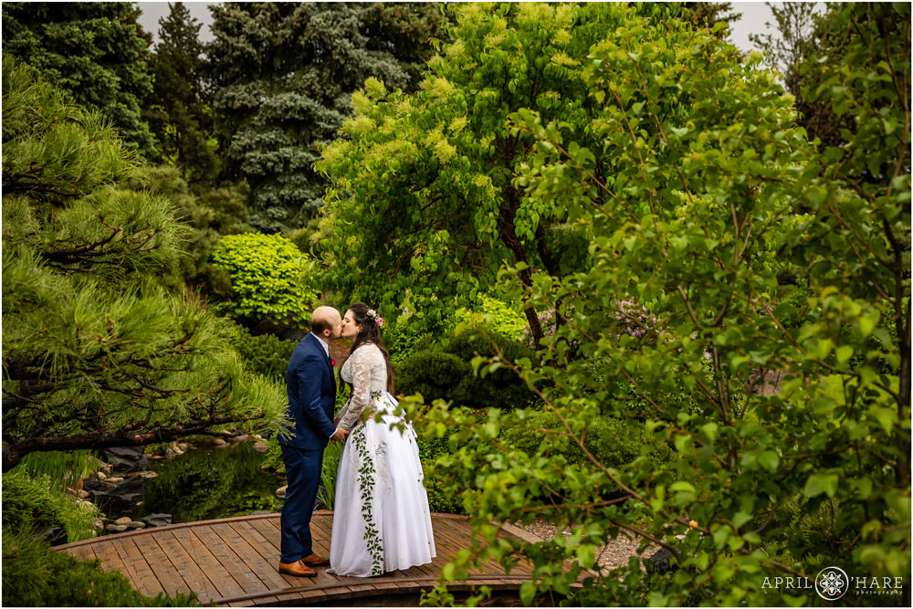 Couple kiss on a wood footbridge in the Japanese Garden area of Denver Botanic Gardens