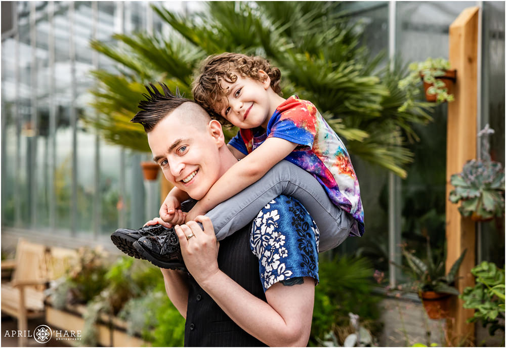 Sweet photo of ringbearer sitting on his uncle's shoulders at a wedding reception at The Orangery at Denver Botanic Gardens