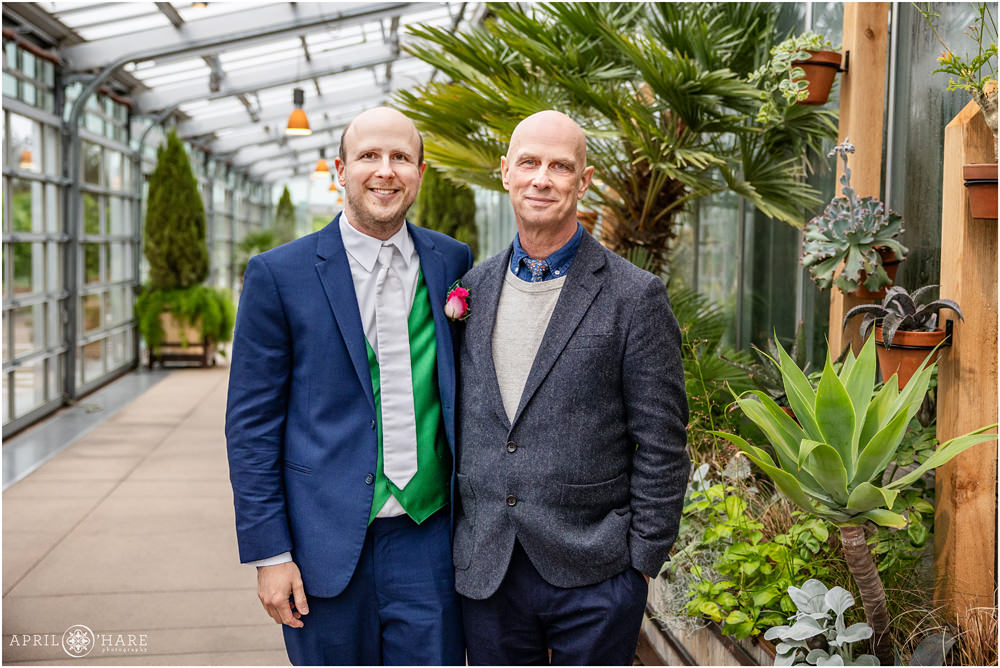 Casual candid photo of groom with his dad inside the Orangery on his rainy wedding day at Denver Botanic Gardens