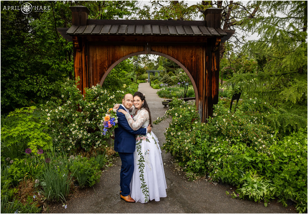 Bride and groom pose for portraits in the June's Plant Asia area of Denver Botanic Gardens next to Japanese style circle arch
