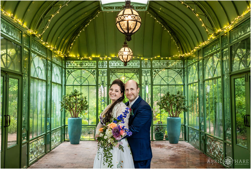 Beautiful Wedding Day Portrait of Bride and Groom Smiling inside the Vintage Green Solarium at Denver Botanic Gardens