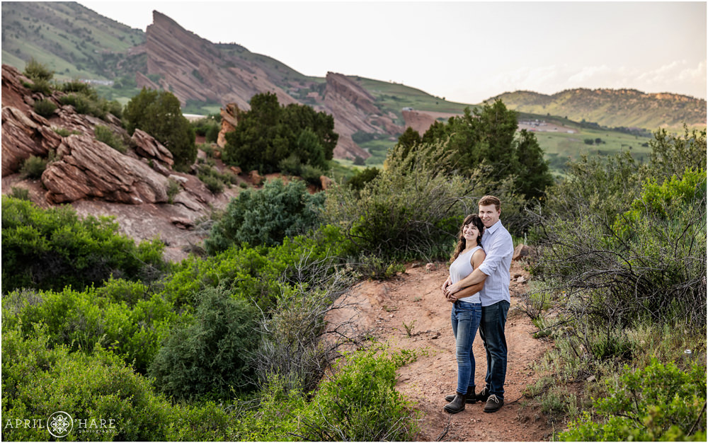 A couple pose for a portrait in the beautiful Red Rocks scenery at East Mount Falcon Trailhead in Morrison Colorado