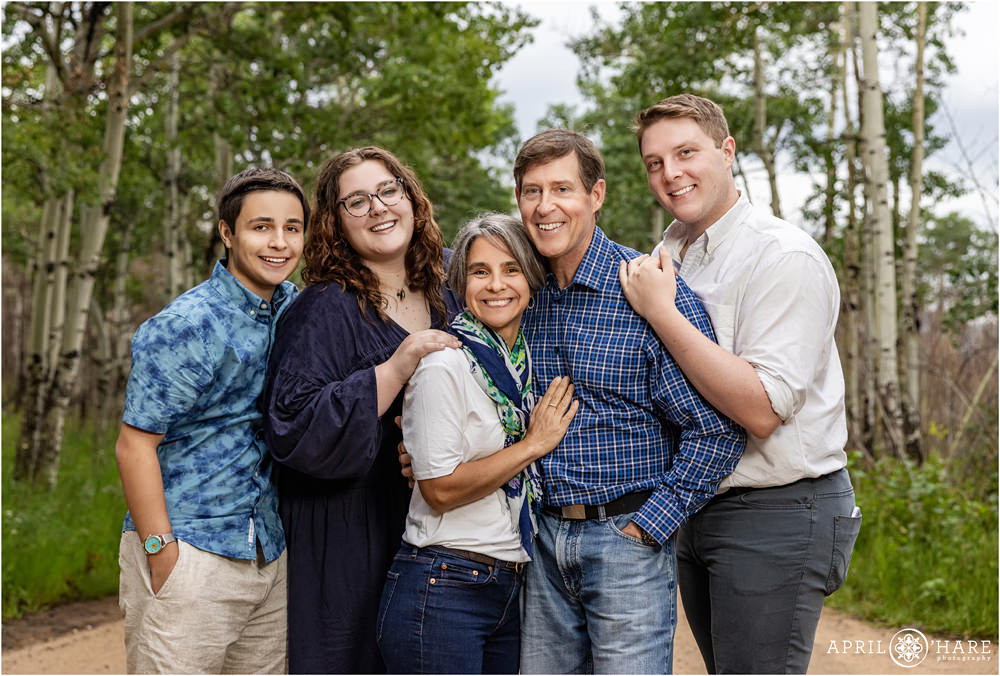 A family of 5 pose for a portrait together in the aspen trees at Rocky Mountain National Park in Estes Park