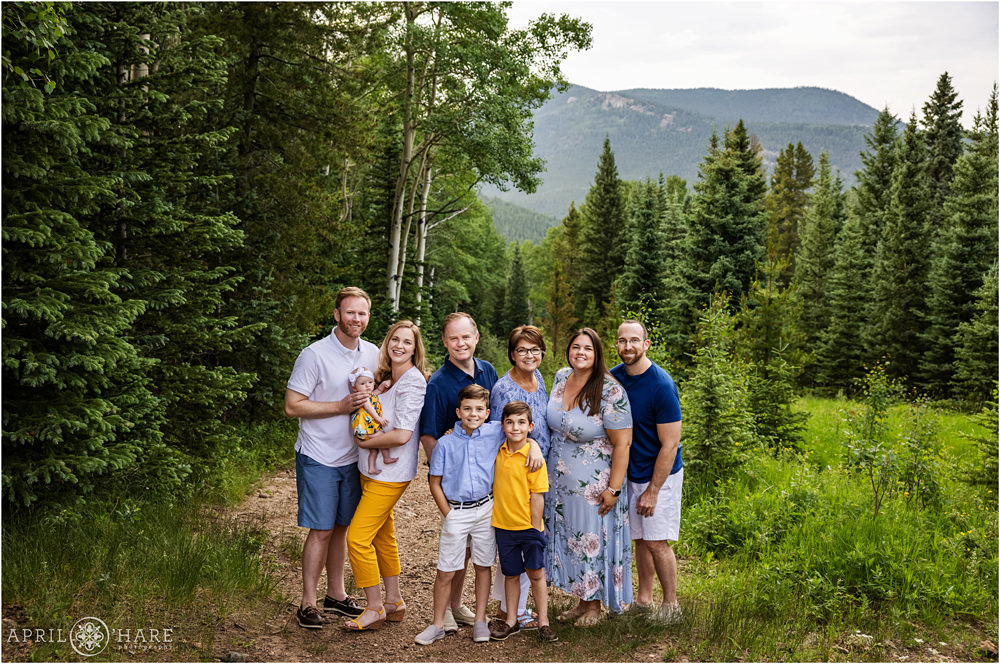 Beautiful extended family portrait with mountain backdrop in a forest in Evergreen Colorado
