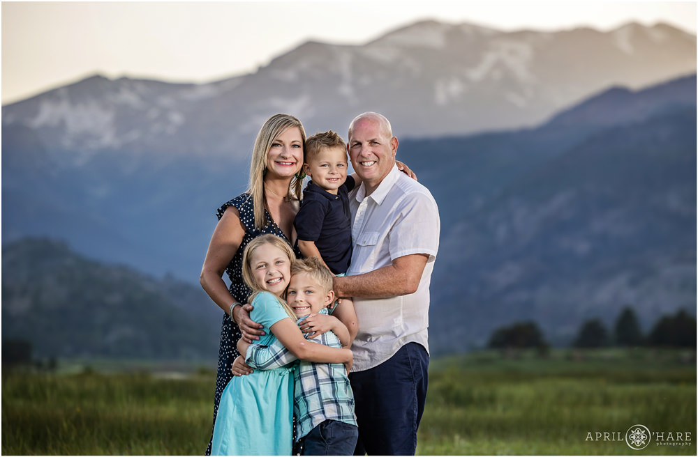 Beautiful sunset photo of a family with pretty mountain backdrop at Rocky Mountain National Park