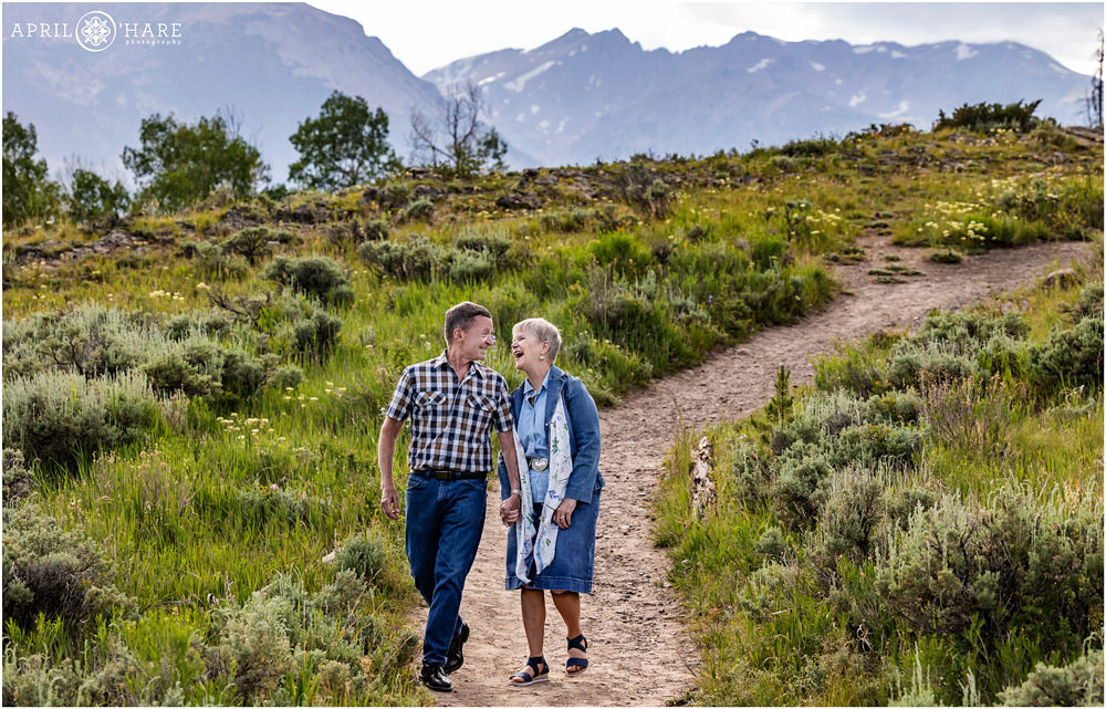 Couple walk down a mountain path hand in hand during summer in Colorado