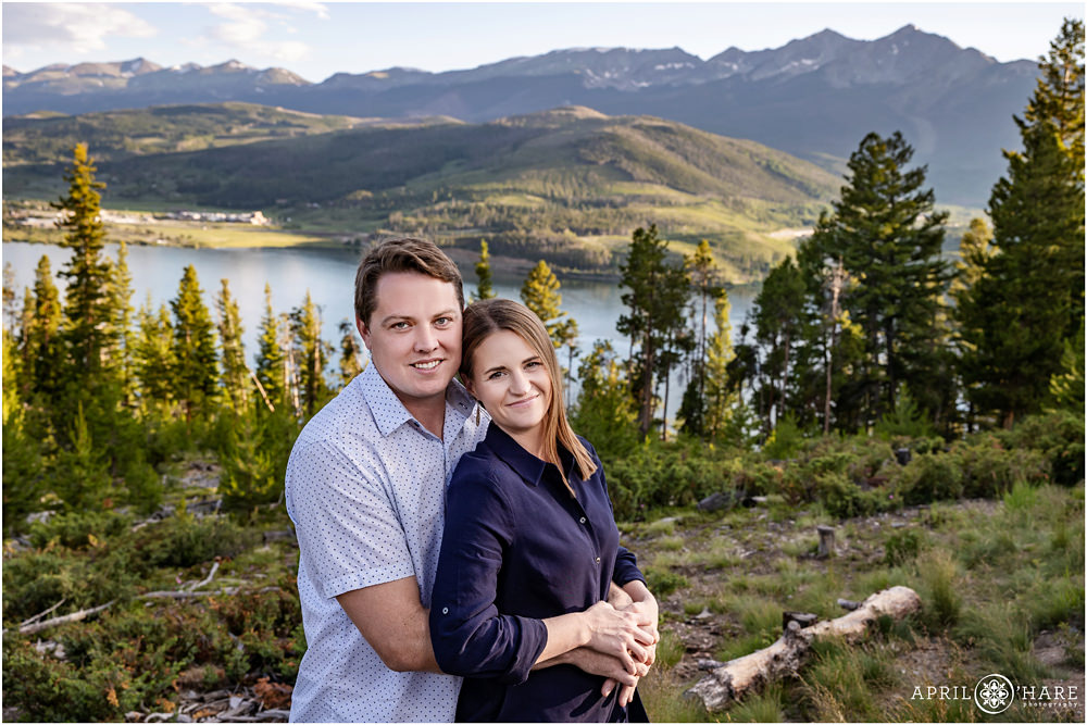 Cute couple snuggle in front of a pretty mountain view in Colorado during summer