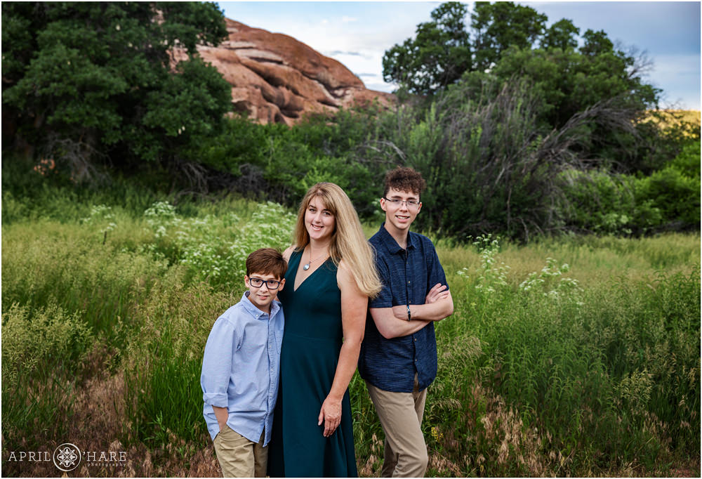 Beautiful summer portrait of a family of 3 with red rocks backdrop in Colorado