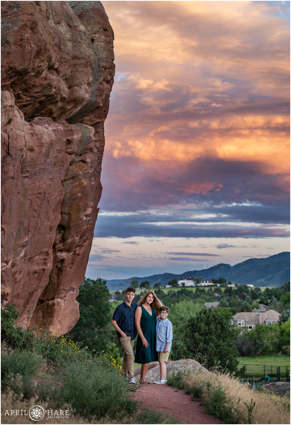 Ken Caryl Family Photos with a beautiful red rocks backdrop and pretty sunset sky and Manor House in the background