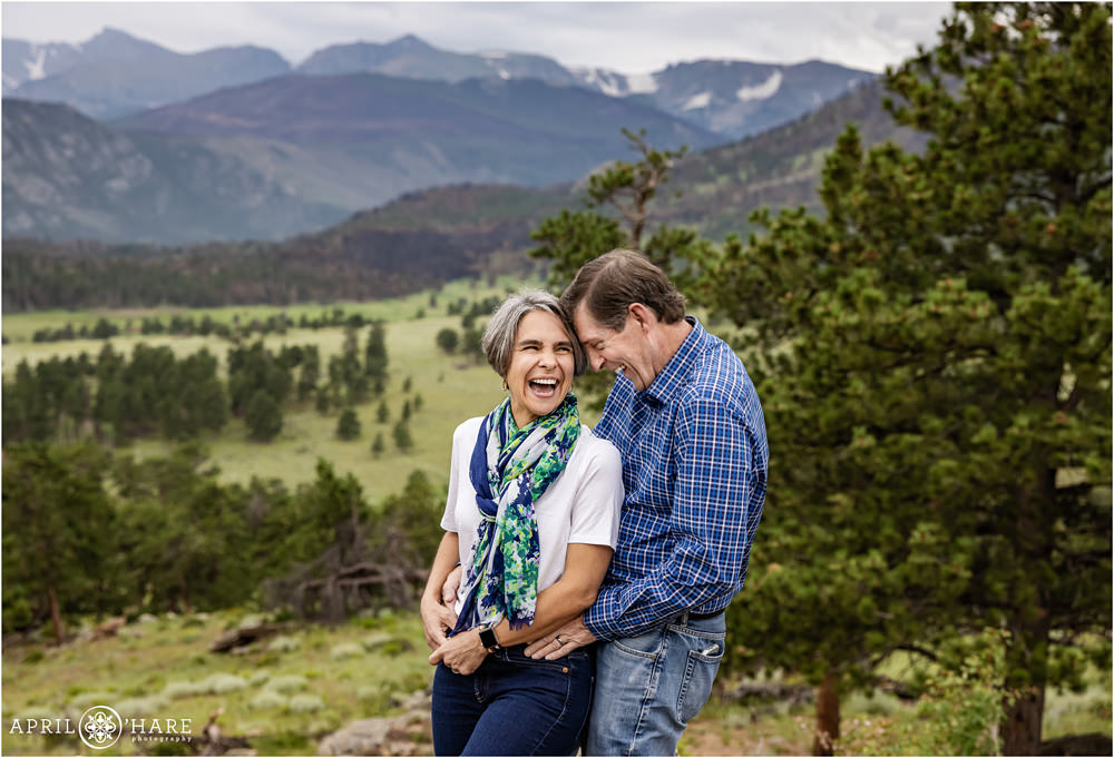 Mom and Dad laugh together with a beautiful mountain backdrop inside of Rocky Mountain National Park during summer