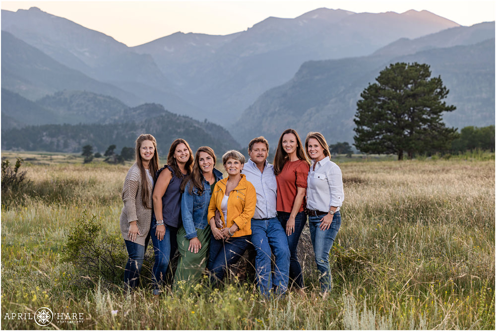 5 adult sisters get a beautiful sunset mountain photo created with their mom and dad while on vacation together in Estes Park Colorado