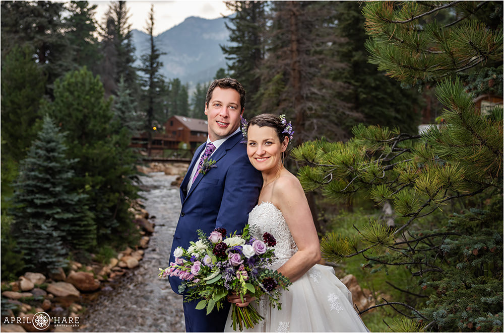 Classic colorful portrait of a bride and groom with fall river and mountain backdrop on their wedding day at Estes Park Condos