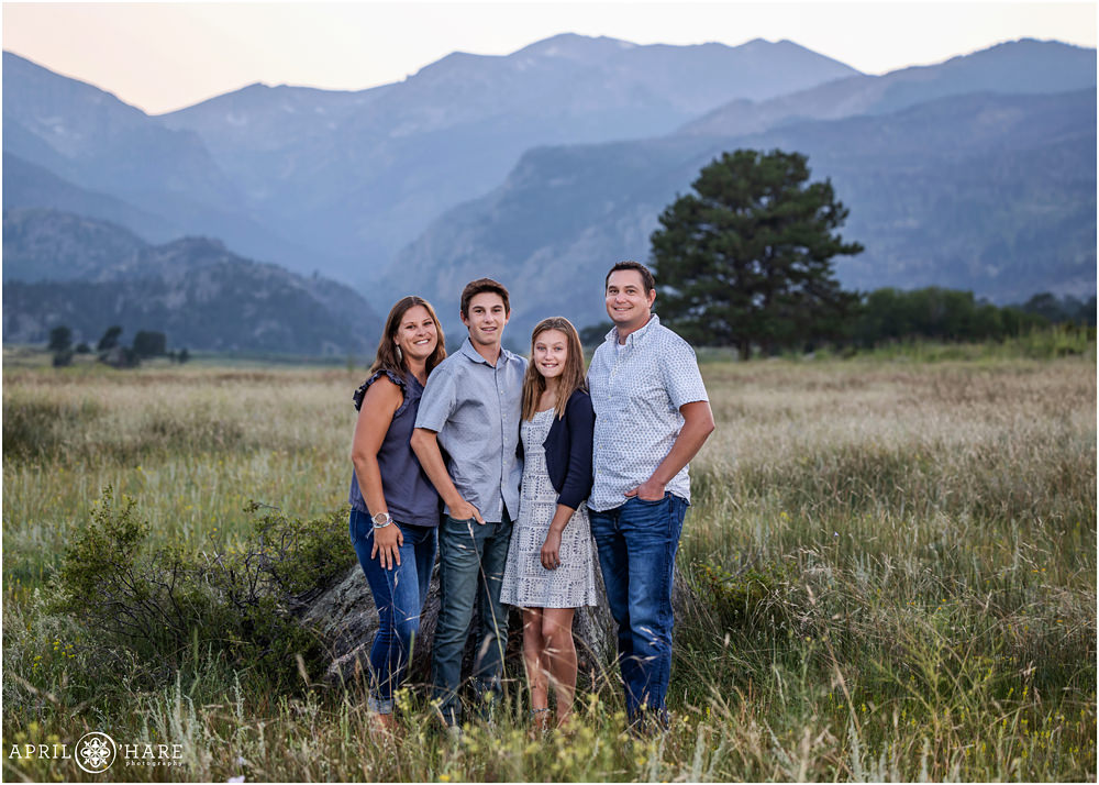 Summer family pictures for a family of 4 all wearing shades of blue with a pretty blue mountain backdrop at Rocky Mountain National Park