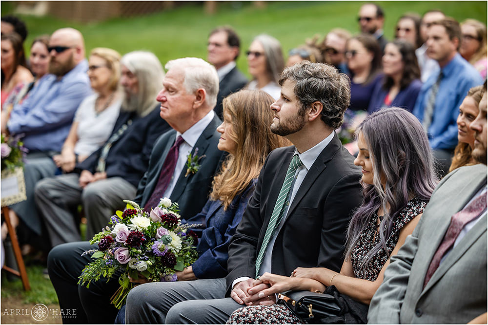 Family and friends look on at an outdoor wedding ceremony on the lawn at Estes Park Condos