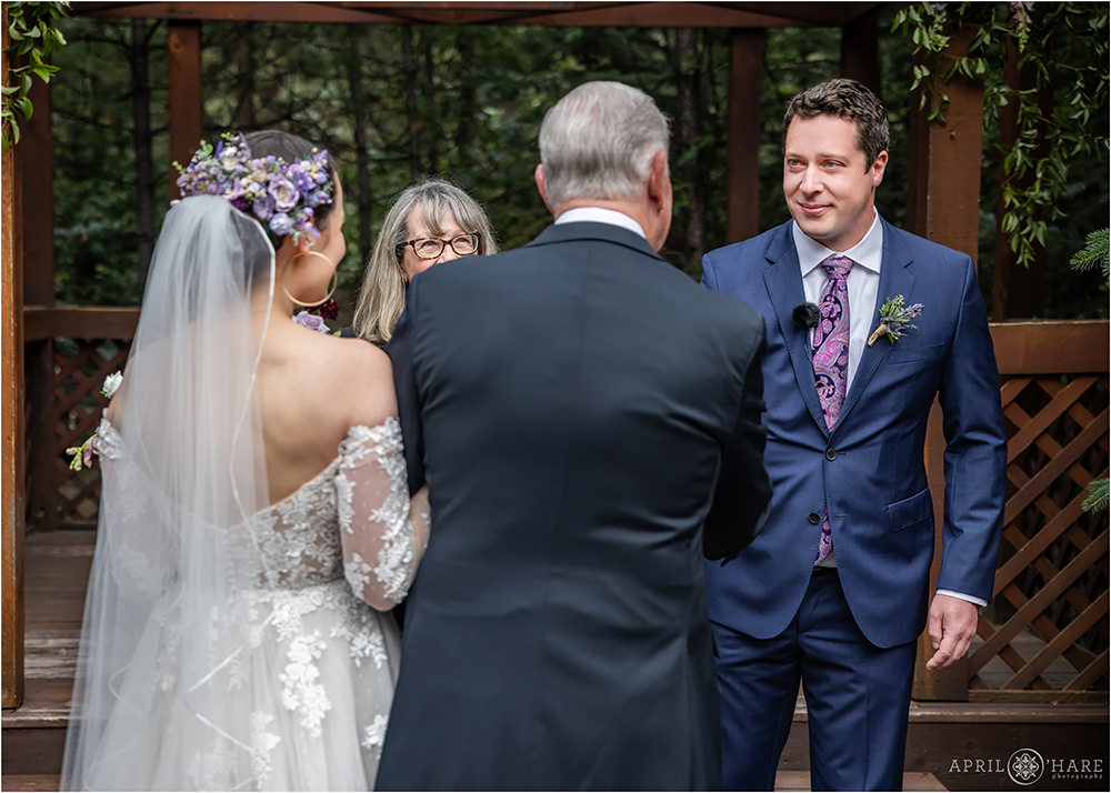 Groom and his father in law shake hands at outdoor wedding ceremony at Estes Park Condos