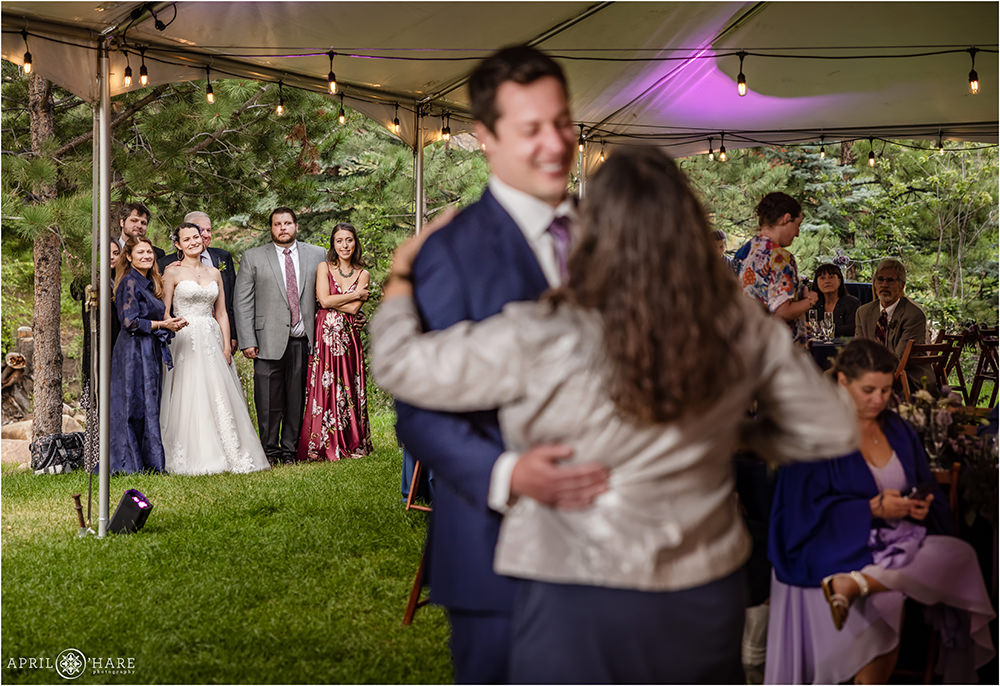 Bride and her family look on at the groom as he dances with his mom at the Estes Park Condos